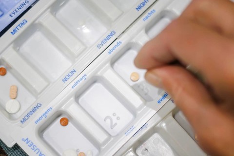 Symbolic photo on the subject of taking medication in old age. Two senior citizens sort various
