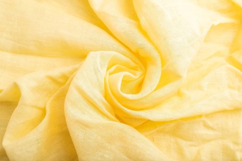 Fragment of yellow linen tissue. Top view, flat lay, natural textile background and texture. wave