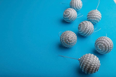 Christmas or New Year composition. Decorations, silver balls, on a blue paper background. Side