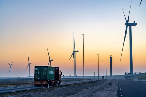 Lorry on the road from Euromax Terminal Rotterdam, ENECO wind farm on the dike around the port of