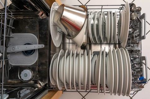 Dishwasher, full, with cleaned crockery, cutlery, cooking utensils
