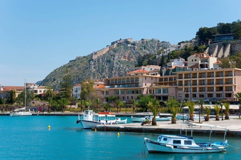 Coastal town with colourful buildings and a harbour full of small boats on turquoise waters,