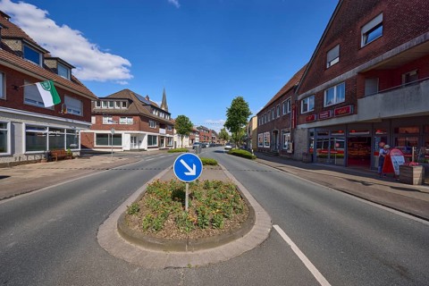 Traffic island with traffic sign for passing on the right on Weseler Strasse in Buldern, Dülmen,