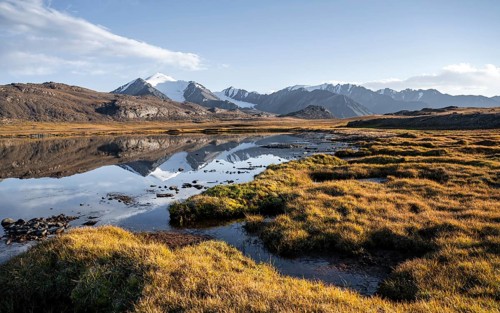 Glaciated mountain peaks reflected in a mountain lake at sunset, Arabel Lake at Arabel Pass, Issyk
