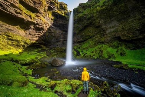 Tourist at Kvernufoss waterfall, in summer when the weather is nice, gorge and river, long
