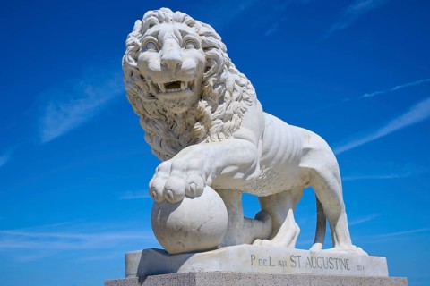 An impressive lion statue on a pedestal, on the Bridge of Lions, St Augustine, harbour, Matanzas
