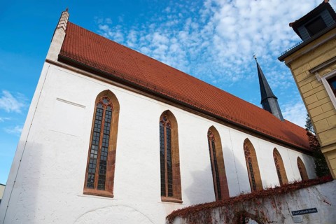 Church with red tiled roof and Gothic windows under a blue sky, St Augustin's Monastery Church,