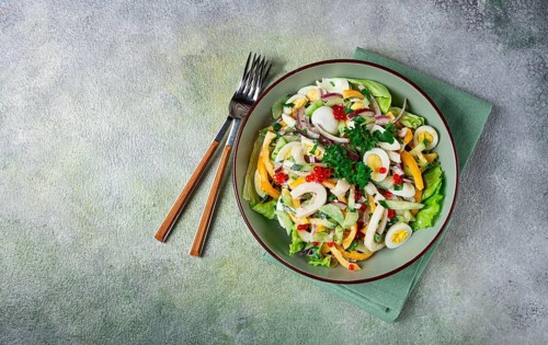 Salad with squid, fresh cucumber, eggs, sweet pepper, red onion, with dressing, homemade, no people