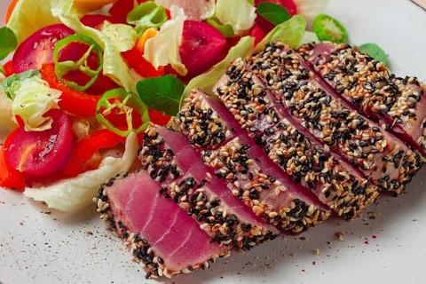 Fillet of red tuna meat, fried in sesame seeds, homemade, close-up, no people, on a wooden