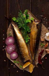 Smoked mackerel, top view, with spices, on a wooden table, no people, selective focus