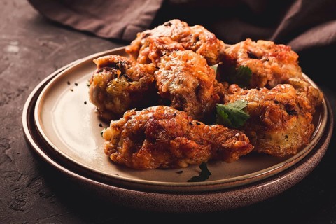 Fried chicken legs, breaded, with spices and herbs, on a dark background, horizontal, no people,