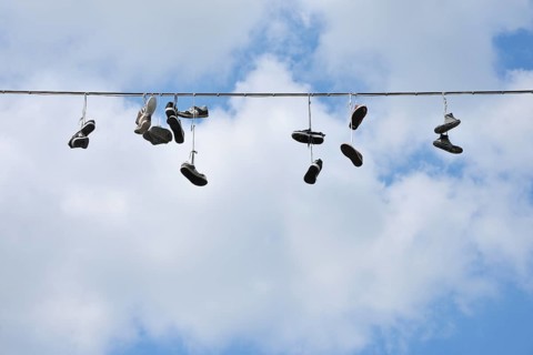 Shoes hanging on a wire against a blue sky with scattered clouds, Bad Mergentheim,