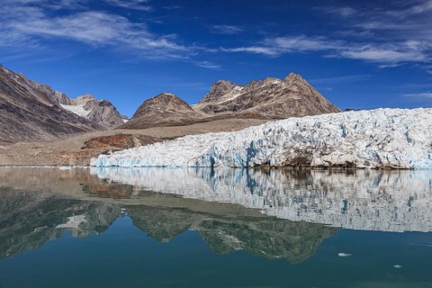 Glaciers and mountains reflected in fjord, sunny, East Greenland, Greenland, North America