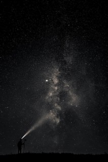 Photographer with tripod and headlamp light in a meadow with starry sky, Mindelheim, Unterallgäu,