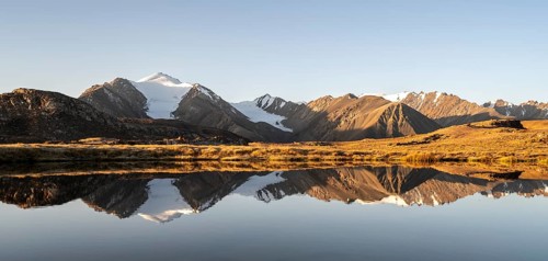 Glaciated mountain peaks reflected in a mountain lake at sunset, Arabel Lake at Arabel Pass, Issyk