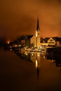 View of Hallstatt with the church and Lake Hallstatt at night. Clouds move through Hallstatt.