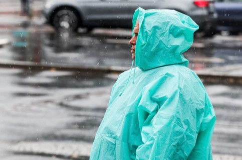A man with a rain cape stands on a street in heavy rainfall, Berlin, 22/06/2024, Berlin, Berlin,