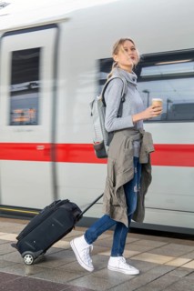 Young woman on the railway track while a train arrives