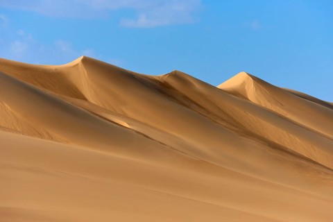 Sand dunes under a blue sky, conveying a calm and vast desert landscape, Matruh, Great Sand Sea,