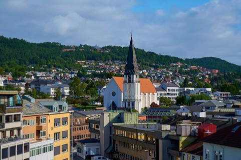 City of Molde with cathedral church and houses as well as mountains and sky in the background,
