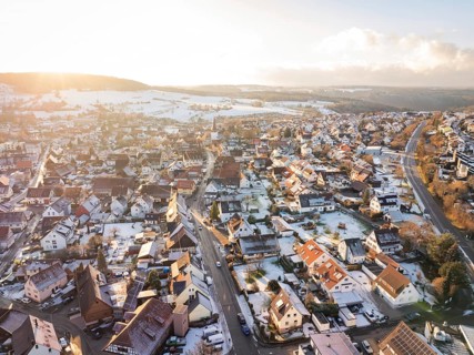 Village street in winter atmosphere, surrounded by snow-covered houses and fields, Calw- Stammheim,