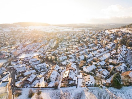 Snowy village in hilly landscape with winter sunlight over the fields, Calw- Stammheim, Black