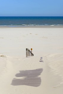 Boardwalk with sand drifts leads to the extensive sandy beach, blue sky, North Sea, Juist, East
