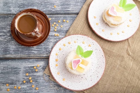Decorated cake with milk and coconut cream with cup of coffee on a gray wooden background and linen