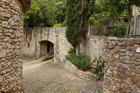 Paths and walls made of natural stone with an archway and Mediterranean gardens in La