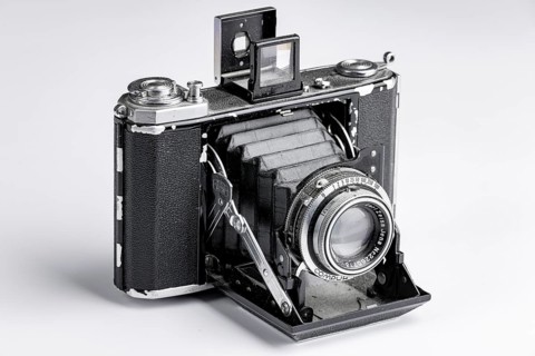 Old bellows camera with extended bellows and opened optical viewfinder
