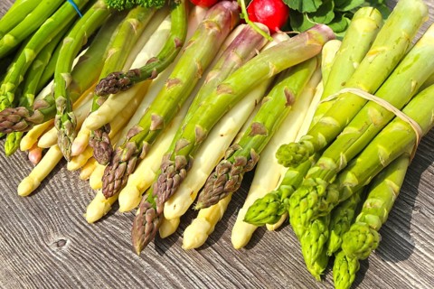 Green asparagus and white asparagus decorated on a rustic wooden table