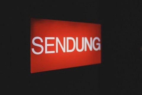 A luminous sign with the inscription 'Sendung' ('Broadcast') indicates a video recording in front