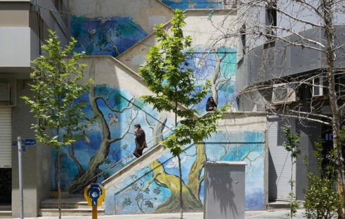 Passers-by walk up a painted staircase in Tehran. The city of Tehran is changing the image of the