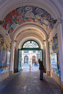A visitor looks at the ceiling painting of a passage in the Museumsquartier, Vienna, Austria,
