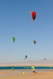 Sailing kitesurfer kite surfer kite surfer on the sea, five kite sails in the blue sky without