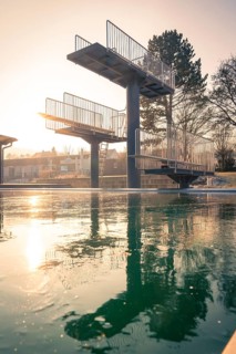 Diving tower with steps in the outdoor pool, immersed in soft evening light with frozen water, ENCW