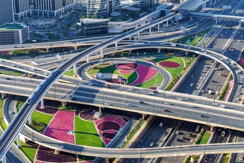 Intersection of Sheikh Zayed Road traffic on the road near the Burj Khalifa with Metro in Dubai,