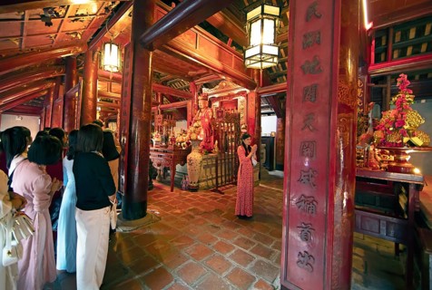 Vietnamese woman pray at the altar of Confucius in the Temple of Literature in the Old Quarter of