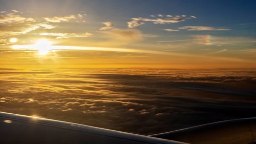 Golden sunrise over a sea of clouds, seen from an aeroplane, flight, aerial photography