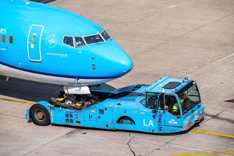 Boeing 737-800 from KLM, being driven from the terminal onto the apron, pushback, with an aircraft