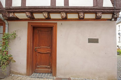 Half-timbered house with seven envious heads and wood carvings, envious head, grimace, faces, front