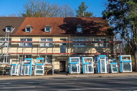 Energy-efficient refurbishment of residential buildings, older apartment block is scaffolded, gets