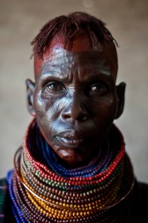 Portrait of a woman from the Turkana tribe, Kenya. Her face is smeared with ochre
