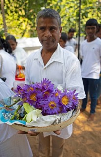 Sri Lankan pilgrim with purple lotus flowers, Holy City of Anuradhapura, North Central Province,
