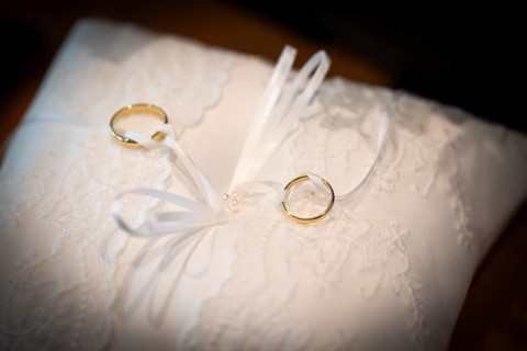 Wedding rings on an ornate white cushion