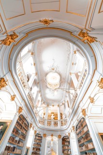 Interior view of a magnificent baroque library with richly decorated ceilings and bookshelves,