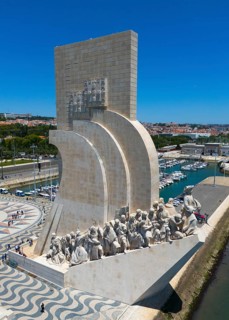 Riverside monument with several statues under a clear sky in an urban environment on a summer day,