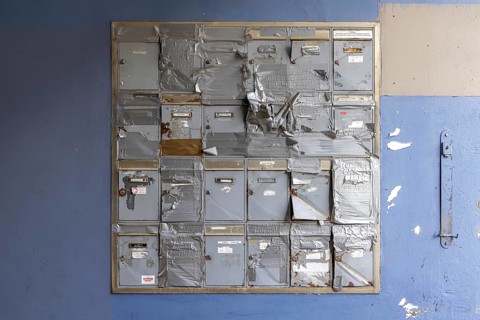 Doorbell sign, broken letterbox system on a dilapidated block of flats in Stuttgart,