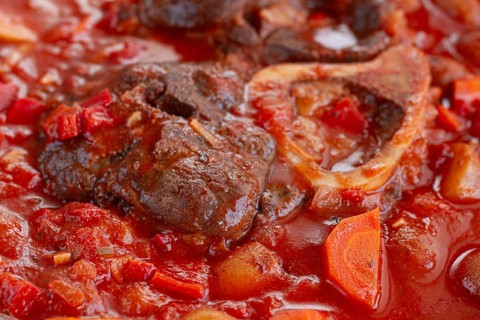 Ossobuco stew with vegetables, knuckle on the bone with new potatoes, in tomato sauce, homemade,