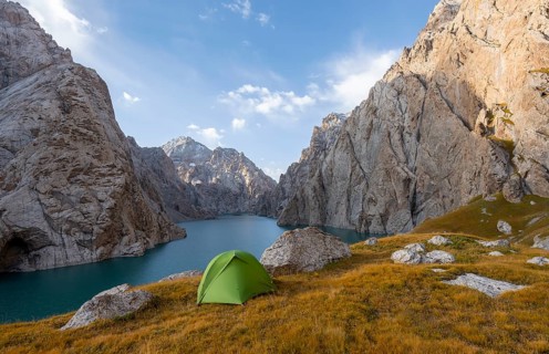 Wild camping, camping in the wilderness with a tent in front of mountain lake Kol Suu, Sary Beles